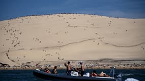Un bateau passe devant la plage et la dune du Pilat, à La Teste-de-Buch, le 8 août 2023.