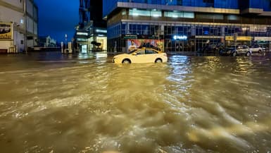Un taxi traverse une rue inondée à la suite de fortes pluies à Dubaï, le 17 avril 2024