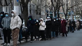 Des Chinois, masqués, font la queue pour se faire tester au Covid-19 à Pékin le 3 décembre 2022