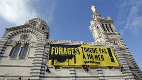 Militants de Greepeace déployant une banderole géante sur la façade de la basilique Notre-Dame de la Garde à Marseille. Le mouvement écologiste français se mobilise dimanche contre un permis de recherche d'hydrocarbures dans une zone en partie protégée de