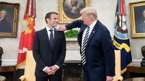 Donald Trump époussetant la veste d'Emmanuel Macron, le 24 avril 2018 à la Maison Blanche.