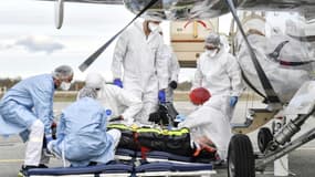 Des équipes médicales évacuent un patient atteint du Covid-19 vers un hôpital où des lits de réanimation sont disponibles, le 27 octobre 2020 à l'aéroport de Bron, près de Lyon 