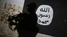 Un membre des forces irakiennes passe devant le logo de Daesh dans le village d'Albu Sayf, près de Mossoul en Irak, le 1er mars 2017. Photo d'illustration