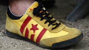 Un homme porte des baskets aux couleurs du drapeau catalan, pendant une manifestation devant le Parlement catalan en 2012.