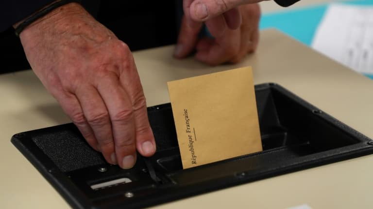 Un électeur glisse son bulletin de vote dans l'urne.