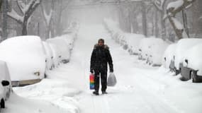 Dans une rue de New York, les véhicules sont ensevelis sous un épais manteau neigeux.