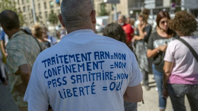 Un opposant au pass sanitaire et à la vaccination manifeste avec d'autres soignants devant l'hôpital de la Timone à Marseille, le 5 août 2021