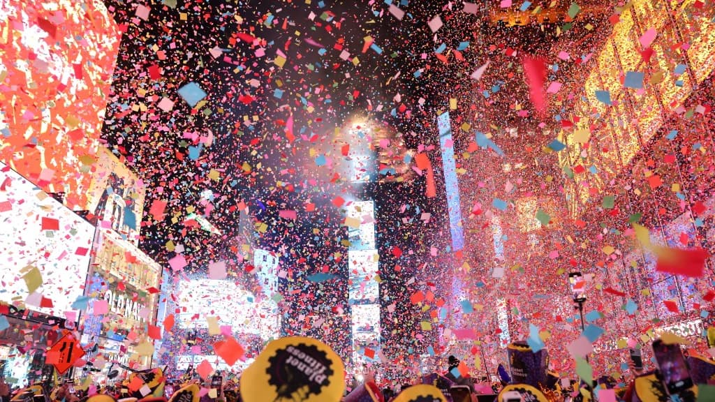 Des badauds regardent les confettis qui remplissent l'air pour marquer le début de la nouvelle année, à Times Square, à New York, le 1er janvier 2023.

