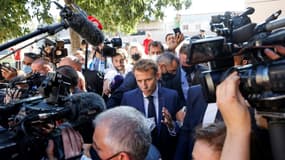 Le président français Emmanuel Macron marche entouré  des médias dans le quartier de Bassens au premier jour d'une visite de trois jours à Marseille, le 1er septembre 2021