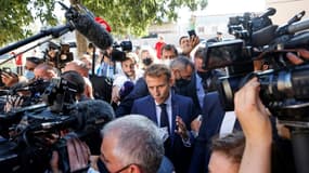 Le président français Emmanuel Macron marche entouré  des médias dans le quartier de Bassens au premier jour d'une visite de trois jours à Marseille, le 1er septembre 2021