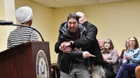 Un homme est maîtrisé après avoir aspergé une substance inconnue sur la représentante américaine Ilhan Omar (D-MN) (à gauche) lors d'une réunion publique qu'elle organisait à Minneapolis, dans le Minnesota (États-Unis) le 27 janvier 2026.