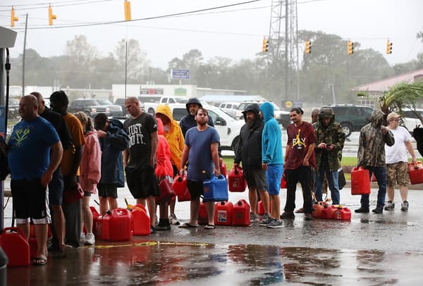 Des habitants de Caroline du Nord font la queue pour acheter de l'essence à une station endommagée, le 15 septembre 2018 à Wilmington. Des habitants de Caroline du Nord font la queue pour acheter de l'essence à une station endommagée, le 15 septembre 2018 à Wilmington.