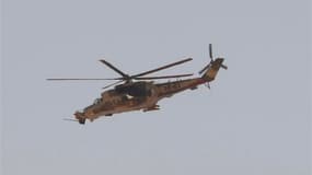 Hélicoptère de l'armée algérienne survolant In Amenas, dans le sud-est de l'Algérie. L'opération de libération des otages dans le complexe gazier voisin de Tiguentourine est encore en cours et des otages sont morts, a déclaré François Hollande samedi lors