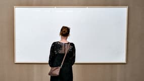 Une femme regarde un cadre vide au musée Kunsten d'Aalborg au Danemark, le 28 septembre 2021, oeuvre de l'artiste Jens Haaning