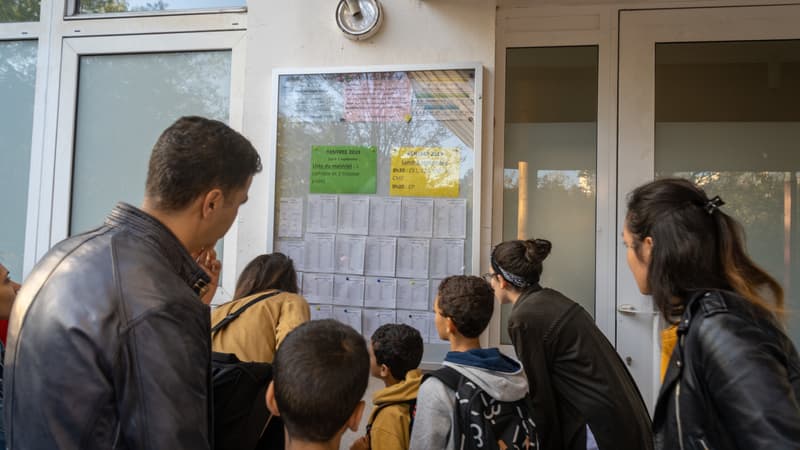 Des enfants et des parents en train de découvrir la composition des classes le jour de la rentrée scolaire à Gennevilliers.