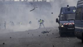 Des manifestants jetant des pavés sur des cars de CRS, sous l'arc de Triomphe -