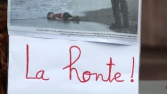 Un enfant tient une pancarte montrant la photo du petit garçon syrien découvert mort sur une plage turque, le 5 septembre 2015 lors d'une manifestation à Strasbourg Un enfant tient une pancarte montrant la photo du petit garçon syrien découvert mort sur une plage turque, le 5 septembre 2015 lors d'une manifestation à Strasbourg