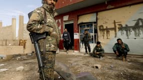 Des combattants de l'alliance arabo-kurde des Forces démocratiques syriennes (FDS) se reposent, à Baghouz