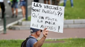 Un manifestant brandissant une pancarte lors d'un rassemblement à Toulouse contre la vaccination et le pass sanitaire.