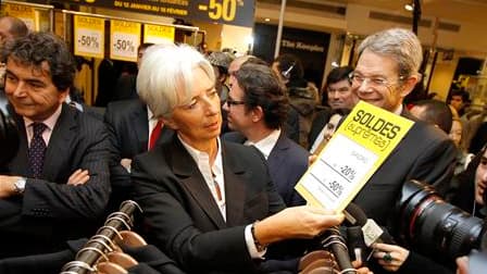 La ministre de l'Economie Christine Lagarde, ici aux côtés du secrétaire d'Etat au Commerce extérieur Pierre Lellouche (à gauche), a lancé mercredi dans les grands magasins parisiens les soldes d'hiver, "période d'accélération de la consommation" indispen