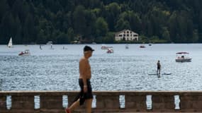 Un homme marche le long du lac de Gérardmer, dans l'est de la France, le 3 août 2022, alors que le niveau d'eau du lac a baissé suite à une vague de chaleur 