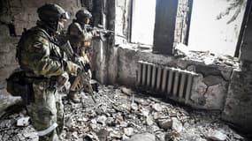 Deux soldats russes patrouillent dans les ruines de la ville de Marioupol, dans le sud-est de l'Ukraine, le 12 avril 2022