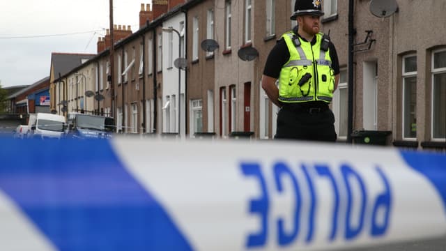 Un officier de police monte la garde près d'une maison de Newport, au Pays de Galles, le 20 septembre 2017, alors que les perquisitions continuent autour de l'attentat du métro de Londres du 15 septembre.