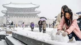 À Séoul, devant le palais de Gyeongbokgung, des Coréennes réalisent des bonhommes de neige. Le 27 novembre 2024.
