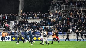 Les supporters font irruption sur la pelouse à la mi-temps du match Paris FC-Lyon comptant pour les 32e de finale de la Coupe de France à Charléty, le 17 décembre 2021 