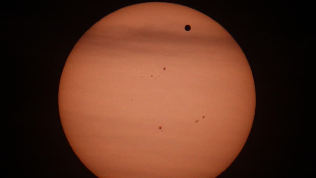 La planète Vénus (le point noir en haut à droite) vue depuis l'observatoire de Vienne, en Autriche, lors d'un passage devant le Soleil, le 6 juin 2012. La planète Vénus (le point noir en haut à droite) vue depuis l'observatoire de Vienne, en Autriche, lors d'un passage devant le Soleil, le 6 juin 2012.