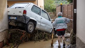 Une femme âgée tente de nettoyer la boue à Montemurlo, à côté de Prato en Toscane (Italie), le 3 novembre 2023, après le passage de la tempête Ciaran