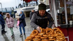 Un vendeur ambulant propose des "simit", ces petits pains traditionnels turcs, sur la place Karaköy à Istanbul, le 27 décembre 2025.