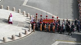 Les porteurs de cercueils, à côté des gardes suisses, portent le cercueil du pape François sur la place Saint-Pierre, alors qu'il est transporté de la chapelle de Santa Marta à la basilique Saint-Pierre, après le décès du pape, au Vatican, le 23 avril 2025.