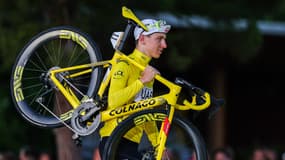 Le Slovène Tadej Pogacar avec son vélo à la main pour l'arrivée du Tour de France, le 21 juillet 2024