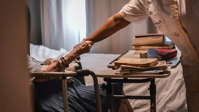 Une personne âgée tenant le bras d'une aide-soignante en juillet 2017, dans un établissement EHPAS parisien.