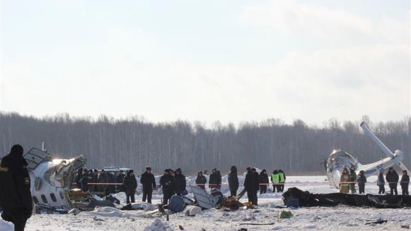 Membres des services d'urgences à l'oeuvre autour de la carcasse d'un avion de ligne russe qui s'est écrasé lundi en Sibérie occidentale avec 43 occupants à bord. L'accident, survenu après le décollage, a fait au moins 31 morts. /Photo prise le 2 avril 20