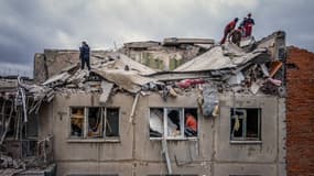 Vue aérienne montrant des sauveteurs au sommet d'un immeuble résidentiel partiellement détruit après un bombardement à Sloviansk, en Ukraine, vendredi