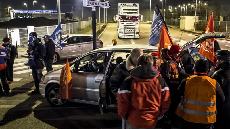 Des routiers bloquent une route d'accès au marché de gros de Corbas, près de Lyon, dimanche soir.