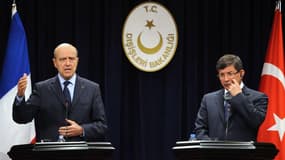 Alain Juppé et son homologue turc Ahmet Davutoglu lors d'une conférence de presse commune à Ankara. La France et la Turquie ont uni leurs voix vendredi pour réclamer une pression accrue sur le régime syrien, sous la menace de sanctions de la Ligue arabe,