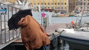 Des passants se protègent de la pluie sous un parapluie à Marseille, en novembre 2011. (Photo d'illustration)