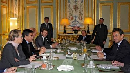 Face à Nicolas Sarkozy, la ministre des Affaires étrangères Michèle Alliot-Marie, le Premier ministre François Fillon, le ministre de l'Intérieur Brice Hortefeux et le porte-parole du gouvernement François Baroin, lors d'une réunion à l'Elysée sur les réc
