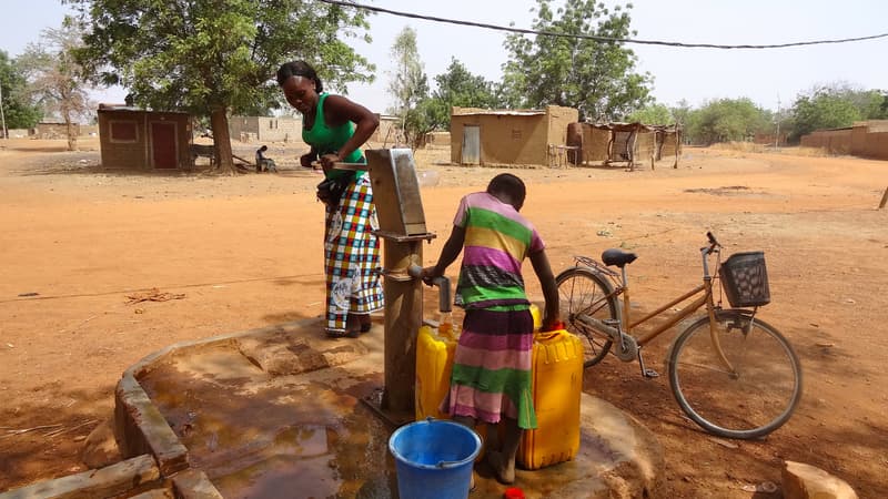 Une femme et une jeune fille en train de prendre de l'eau dans un village du Burkina Faso (Photo d'illustration).
