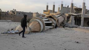 Un homme passe devant un minaret détruit dans la ville de Raqa, fief du groupe Etat islamique en Syrie