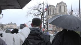 Des badauds atroupés aux abords de la cathédrale Notre-Dame de Paris, alors que la messe inaugurale de l'édifice se déroule à l'intérieur, le 8 décembre 2024, au lendemain de sa réouverture officielle.
