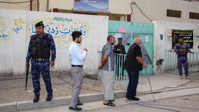 Des Irakiens attendent devant un bureau de vote, le 12 mai 2018, à Bagdad.