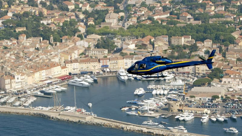 Un hélicoptère transportant un groupe de touriste survol le port de Saint-Tropez, le 30 juin 2006.