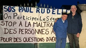 Paul Rudelle, 83 ans et son voisin Christian Houlès devant une affiche de l'association SOS Paul Rudelle dans le Tarn, en février 2025. 