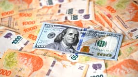 Un billet de 100 dollars américains au-dessus de pesos argentins (photo d'illustration).
