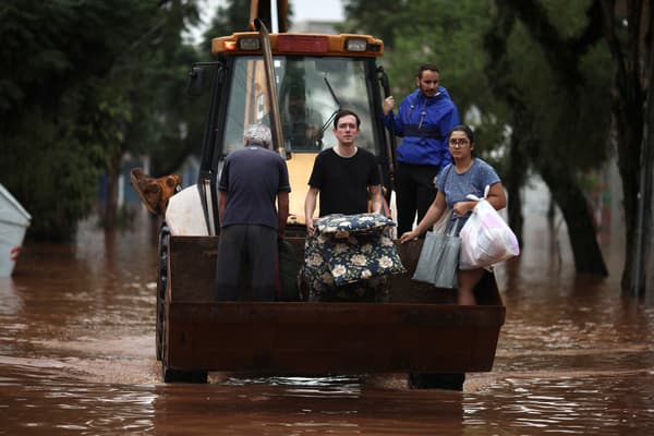 Des personnes sont évacuées d'une zone inondée à l'aide d'une pelleteuse dans le quartier de São Geraldo à Porto Alegre, dans l'État du Rio Grande do Sul, au Brésil, le 4 mai 2024.