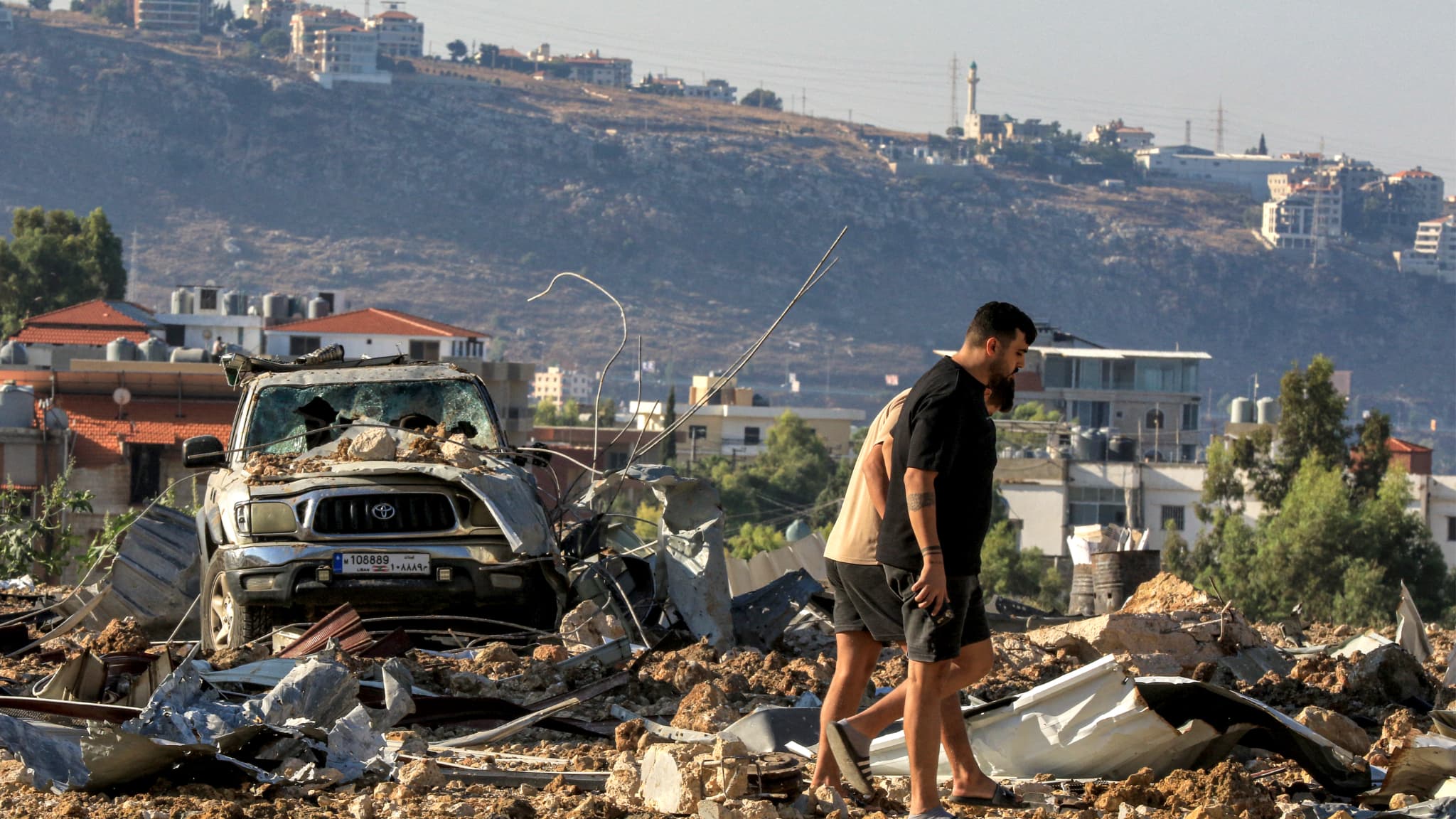 Des personnes inspectent le site d'une frappe aérienne israélienne à Jiye au sud de Beyrouth, le 25 septembre 2024.